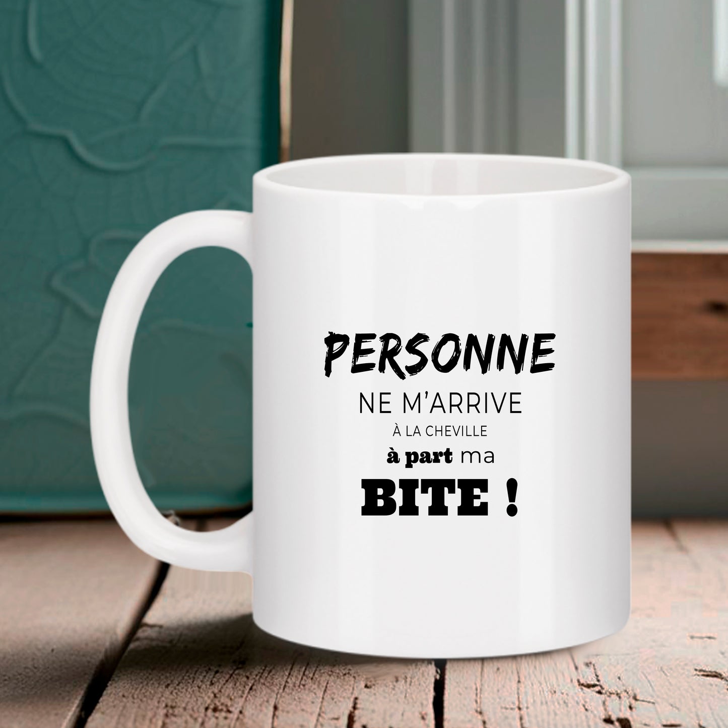 Mug blanc Bruhle avec texte humoristique noir : Personne ne m'arrive à la cheville à part ma BITE ! écrit avec différentes polices de caractères.