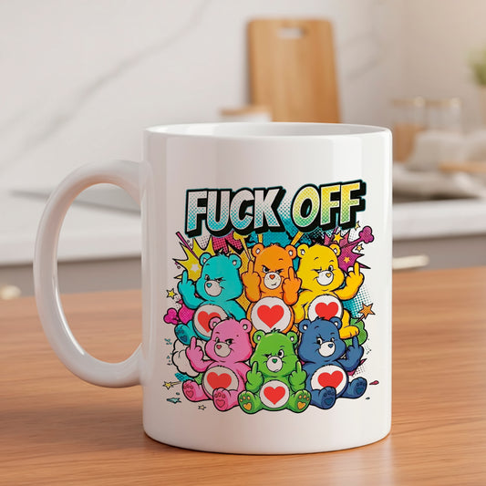 Un mug en céramique blanche sur une table en bois dans une cuisine, affichant un design coloré avec six oursons de styles différents faisant des gestes et le texte "FUCK OFF" au-dessus, dans un style pop art et bande dessinée.