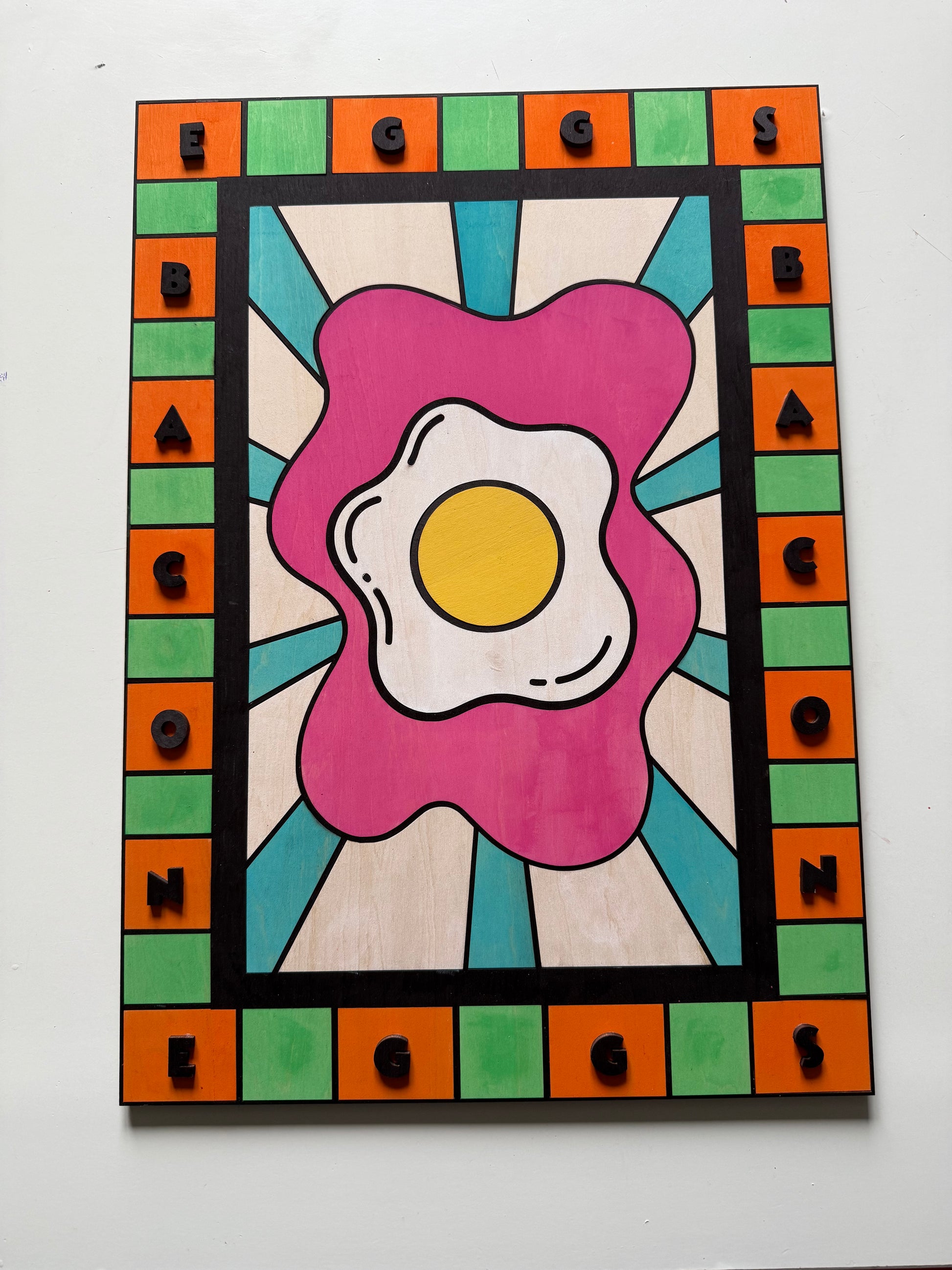Tableau Pop Art petit-déjeuner suspendu sur un mur de cuisine en carrelage blanc, décoration artisanale en bois.