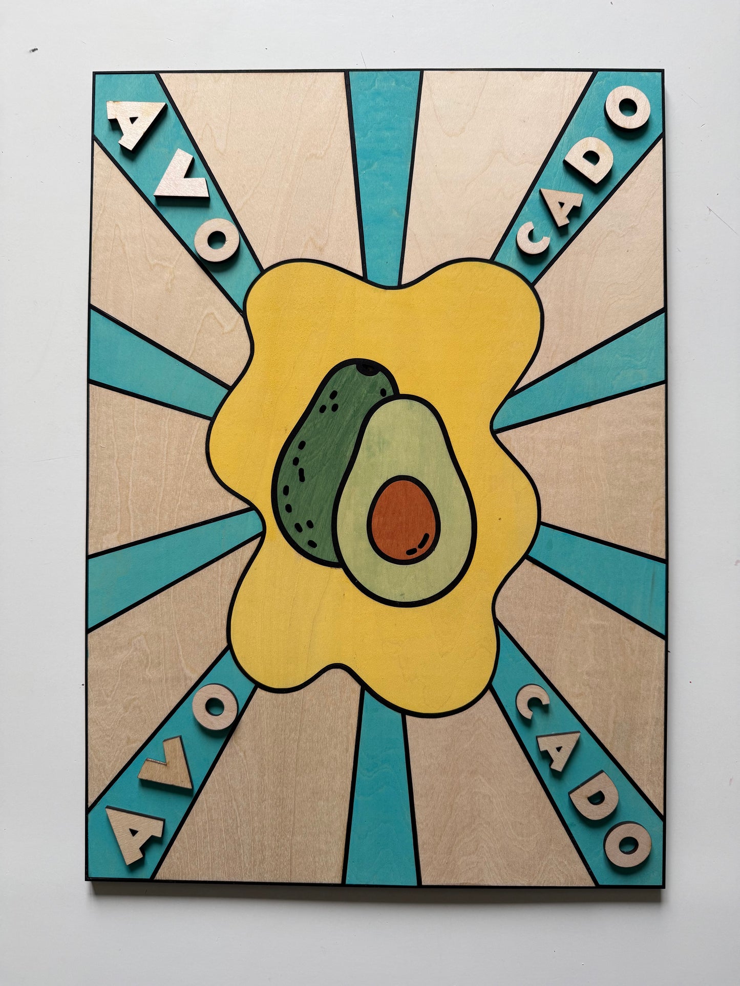 Gros plan sur la découpe laser et la peinture artisanale d'un tableau fraise en bois de bouleau, montrant le relief des lettres.