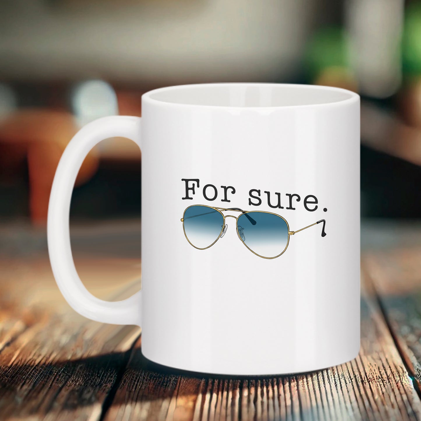 Mug blanc Bruhle avec l'inscription "For sure." en police dactylographiée au-dessus d'une paire de lunettes de soleil de type aviateur avec des verres dégradés bleus.