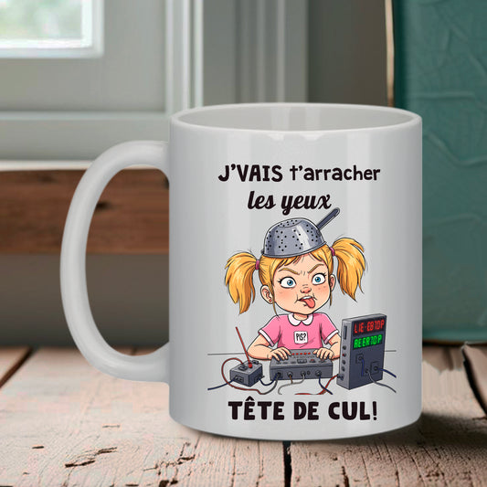 Mug blanc Bruhle montrant une petite fille avec une passoire sur la tête manipulant des consoles électroniques colorées, texte J'vais t'arracher les yeux tête de cul.
