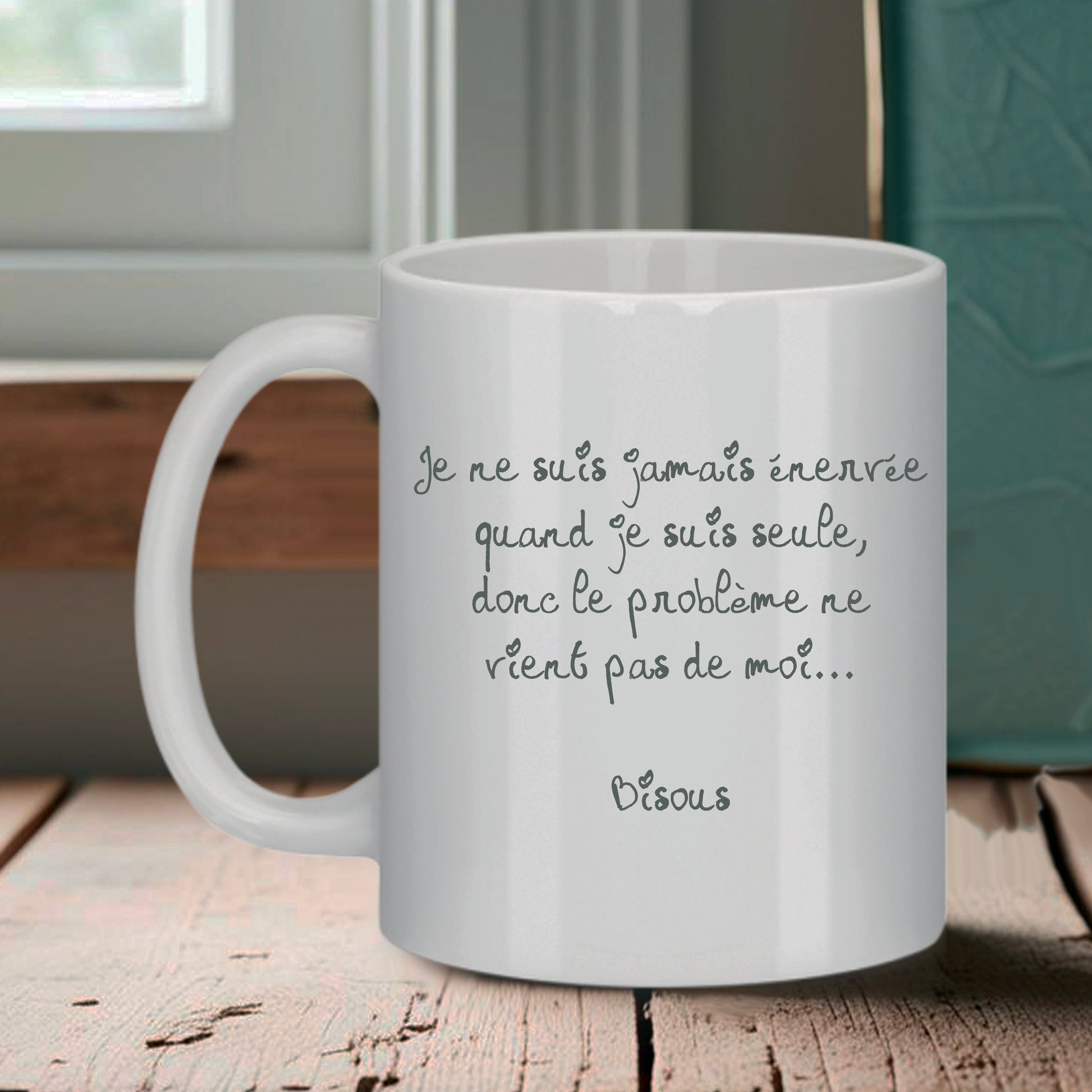 Tasse blanche Bruhle avec un texte noir en cursive : Je ne suis jamais énervée quand je suis seule, donc le problème ne vient pas de moi... Bisous.