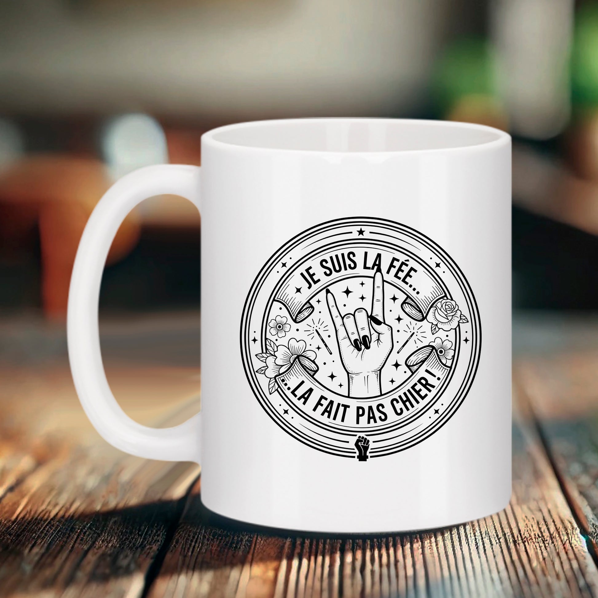 Tasse blanche féministe Bruhle avec un logo circulaire noir style tatouage affichant le texte JE SUIS LA FÉE... LA FAIT PAS CHIER ! avec une main faisant le signe rock.