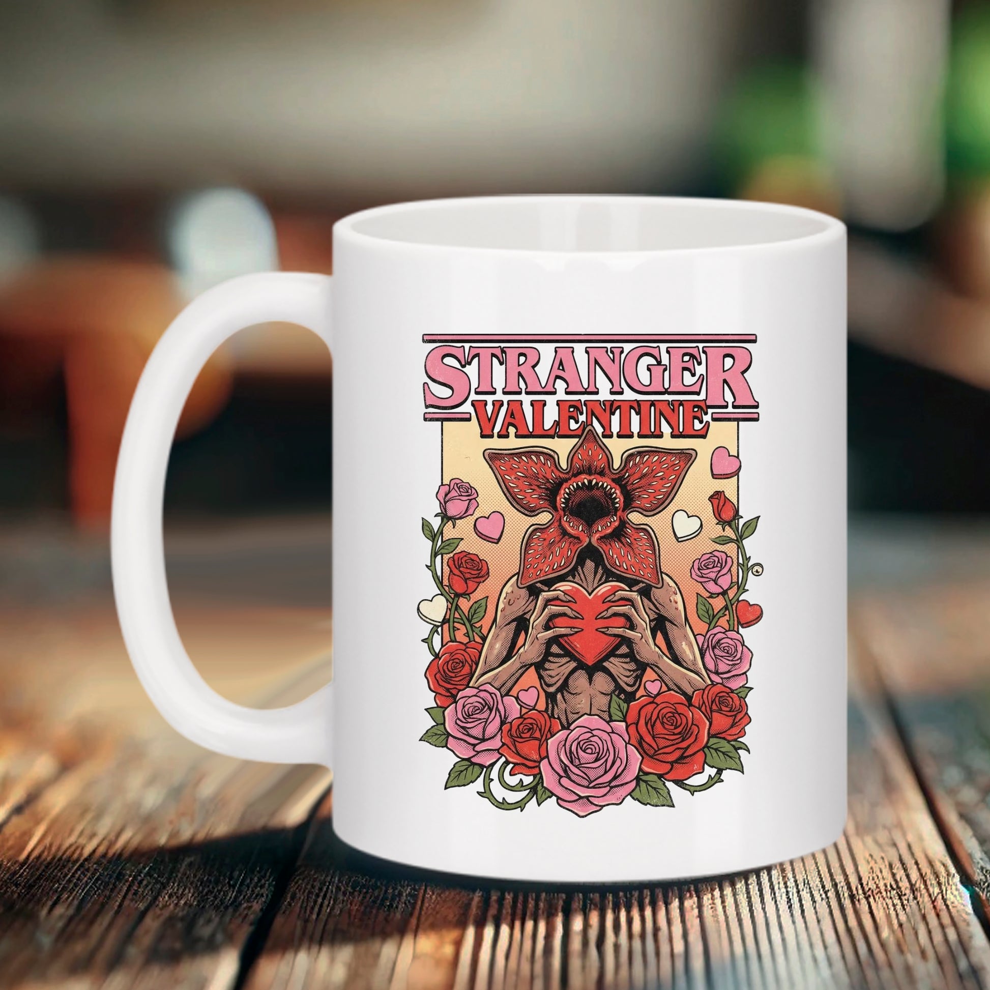 Mug blanc Bruhle avec illustration d'un Demogorgon tenant un cœur rouge entouré de roses, texte "STRANGER VALENTINE" ref stranger things style série fantastique 80s.