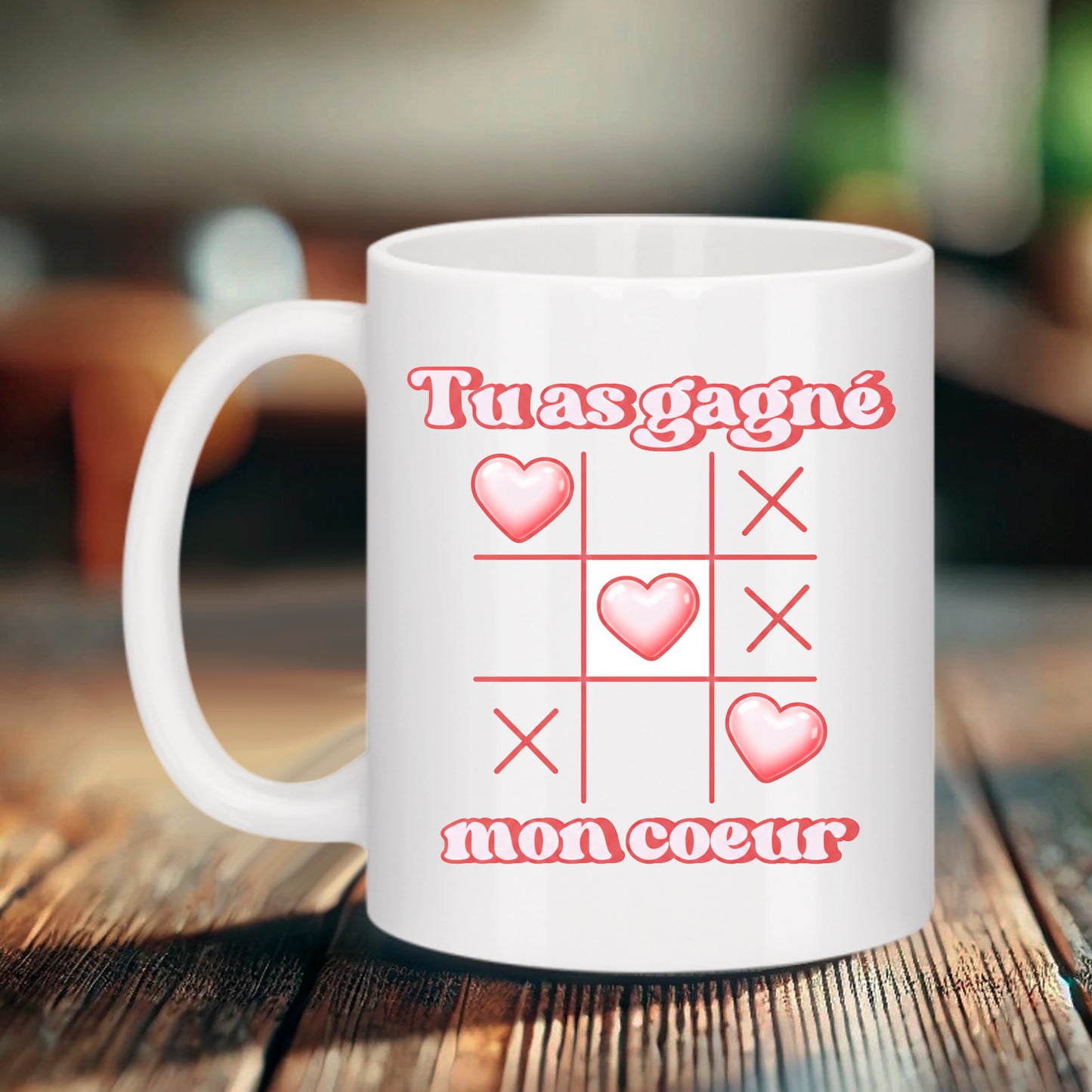 Mug blanc Bruhle avec une grille de morpion affichant trois cœurs roses alignés et le texte "Tu as gagné mon cœur" en rose.